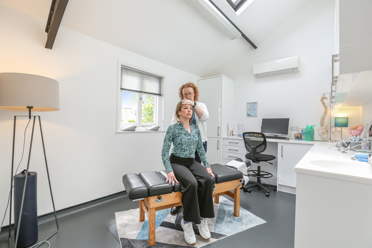 Kelly performing a cervical assessment for headache treatment at Kingston Chiropractic